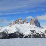 Zasněžená sjezdovka pod masivem Sassolungo v italských Dolomitech